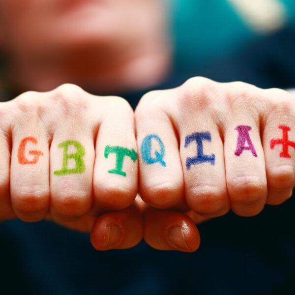 Vibrant hands displaying LGBTQIA+ pride symbols with rainbow colors.