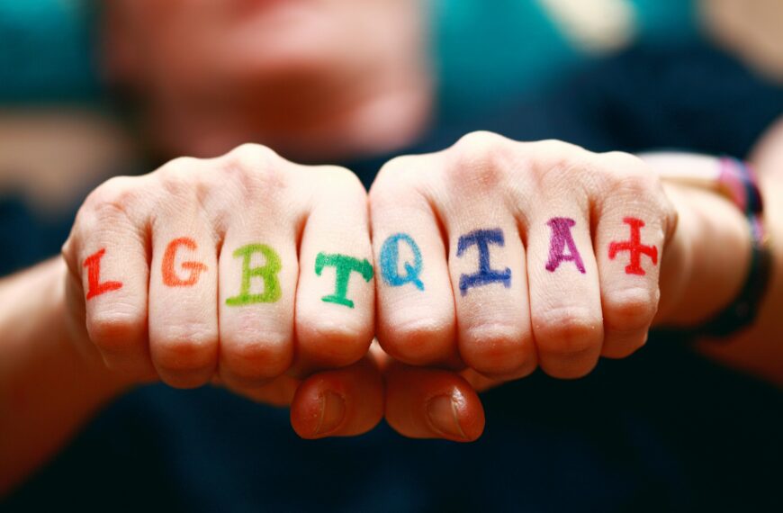 Vibrant hands displaying LGBTQIA+ pride symbols with rainbow colors.